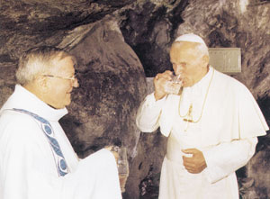 Jan Paweł II pije wodę z cudownego źródełka w Lourdes